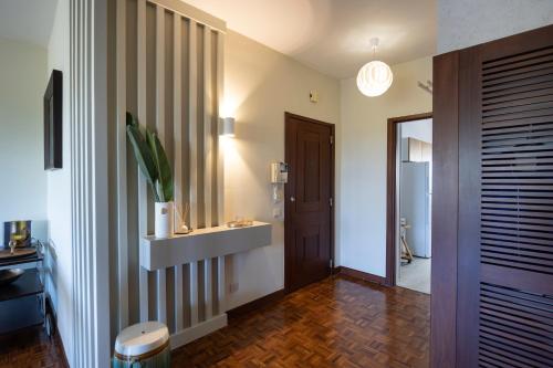 een hal met een badkamer met een wastafel en een spiegel bij SUBLIME Apartment next to the sea in Oeiras