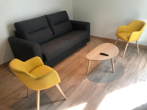 uma sala de estar com duas cadeiras e um sofá em HOTEL MONTE PERDIDO em Bielsa