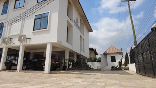 Un edificio blanco con un coche aparcado delante. en MILTON AVENUE SUITES, 2Bed, en Accra