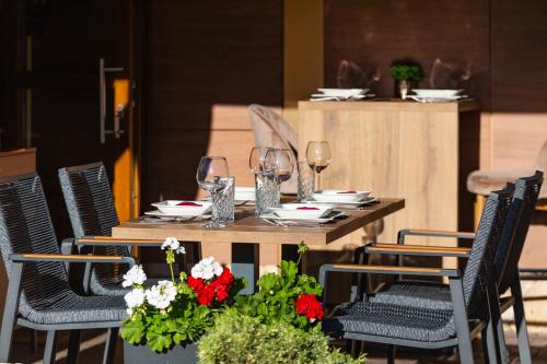 a table with wine glasses and flowers on it at Grand Lakes Rooms in Plitvička Jezera