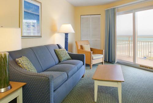 a living room with a blue couch and a table at Fantasy Island II in Daytona Beach Shores