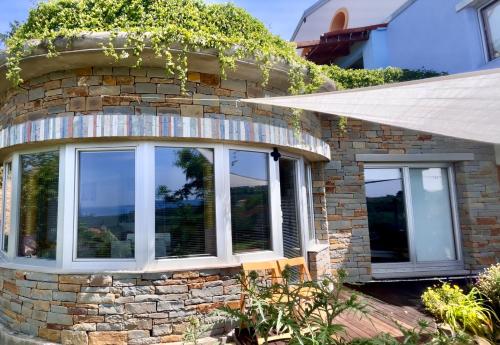 a stone house with windows and ivy at VILLA mandala in Ankaran