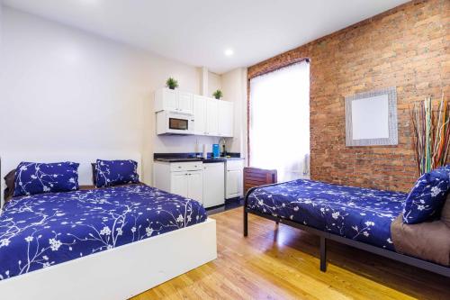 a bedroom with two beds and a brick wall at Studios in New York in New York