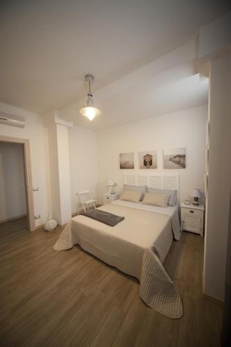 a white bedroom with a large bed and wooden floors at Dear Venice Bed & Breakfast in Marghera