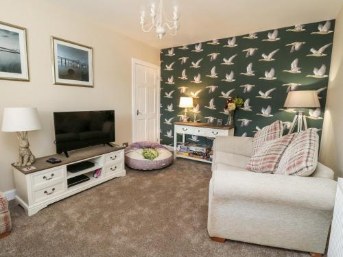 a living room with a couch and a tv at Ulla Dhu in Nethy Bridge