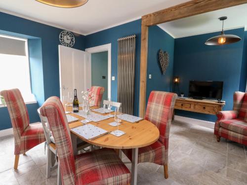 a dining room with a wooden table and chairs at Ulla Dhu in Nethy Bridge