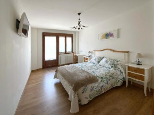 a bedroom with a bed and a table and a television at Apartamento Valbuena in Potes