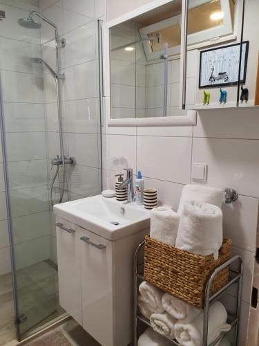 a white bathroom with a sink and a shower at Batala1-City marina apartment with secured private parking in Dubrovnik