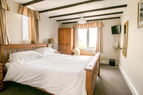 a bedroom with a large bed and a window at Raddicombe Lodge in Brixham