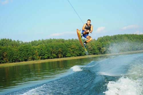 un hombre en una tabla en el aire sobre un lago en Pirties namelis ant ežero kranto en Trakai