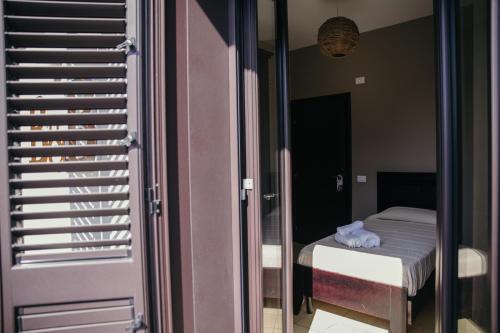 a room with a bed and a glass door at Le Antiche Colonne in Cinquefrondi