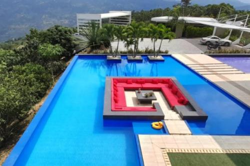 a large swimming pool with a red bench in the middle at LUXURY VILLA Campestre Piscina Privada Anapoima Colombia in Anapoima