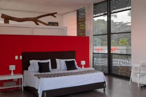 a bedroom with a large bed with a red wall at LUXURY VILLA Campestre Piscina Privada Anapoima Colombia in Anapoima