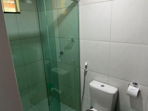een badkamer met een glazen douche en een toilet bij Pousada Solar Maia Costa in Atins