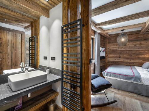 un bagno con lavandino e un letto in una camera di Chalet Val-d'Isère, 5 pièces, 10 personnes - FR-1-567-34 a Val dʼIsère