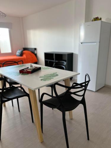a table and chairs in a room with a refrigerator at APART trelew 5 in Trelew