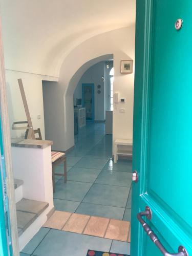 a hallway with a blue door and a hallway with a table at IL MELOGRANO La Casa nel Vicoletto in Lanciano