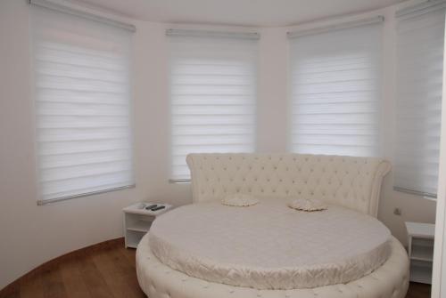 a white bed in a room with windows at Castello in Zatonje
