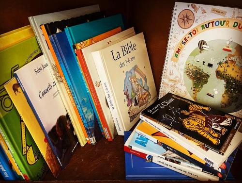 a pile of books sitting on top of a table at Maison 1823 - Suites de charme à Garons in Garons