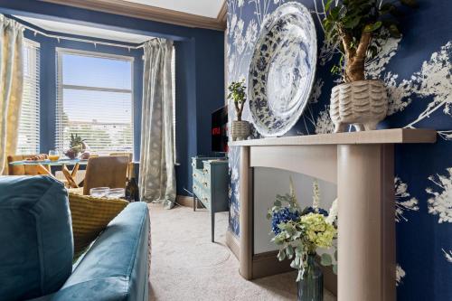 a living room with blue walls and a blue couch at Elberry at Dart Valley Coastal Apartments in Paignton