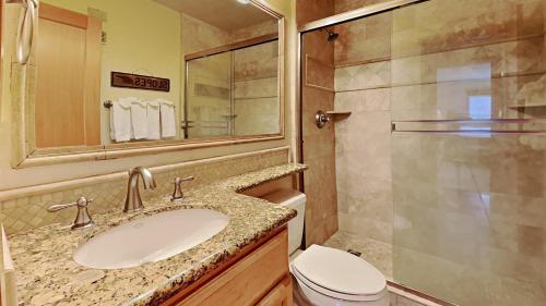 a bathroom with a sink and a toilet and a mirror at Spacious One Bedroom Condo in Mammoth! Free Assigned Parking - Snowbird 107 in Mammoth Lakes