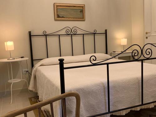 a bedroom with a bed with a wrought iron bed frame at Dimora del Castellano CASA SATURNO in Gioia del Colle