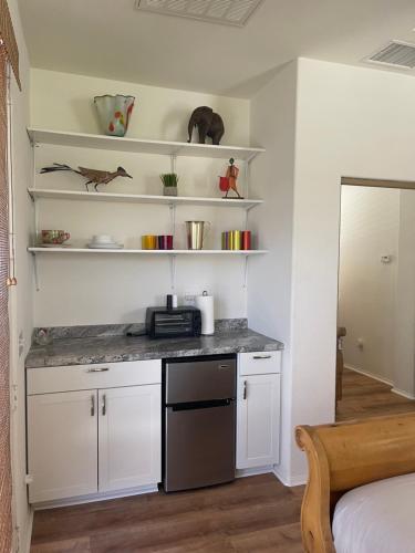 a kitchen with white cabinets and a counter top at Quaint Cochella Music Festival Casita in Indio