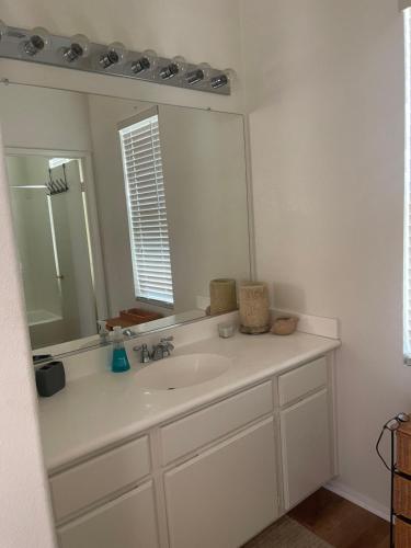 a bathroom with a sink and a large mirror at Quaint Coachella Music Festival Casita in Indio