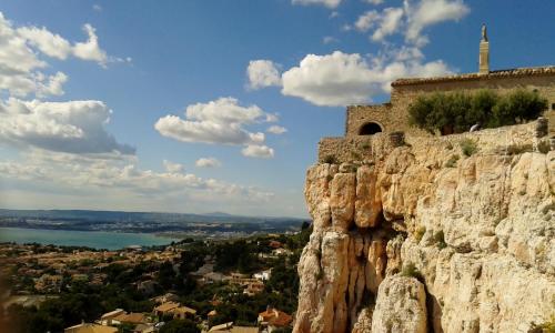 a stone cliff with a church on top of it at Ibis Budget Marseille Vitrolles in Vitrolles