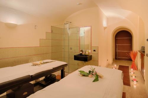 a bathroom with two beds and a shower at GH Palazzo Suite & SPA in Livorno