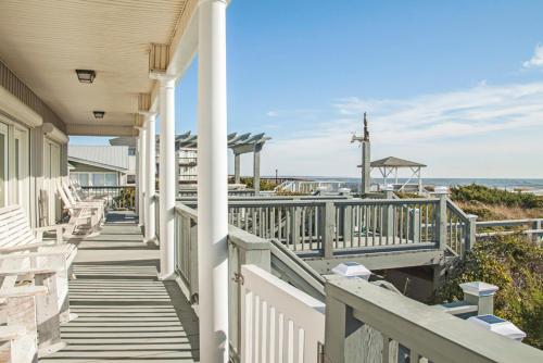 a porch of a house with a view of the beach at Fairwinds by Oak Island Accommodations in Caswell Beach
