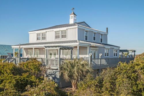 a large white house with a lighthouse on top at Fairwinds by Oak Island Accommodations in Caswell Beach
