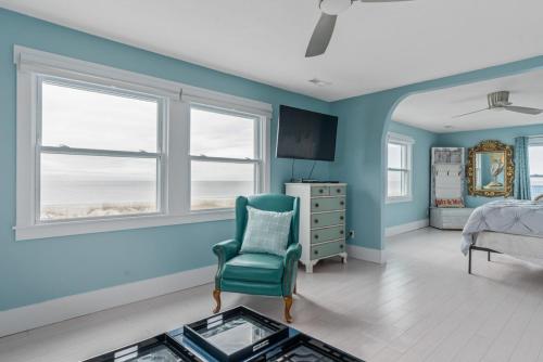 a bedroom with blue walls and a bed and a chair at Fairwinds by Oak Island Accommodations in Caswell Beach
