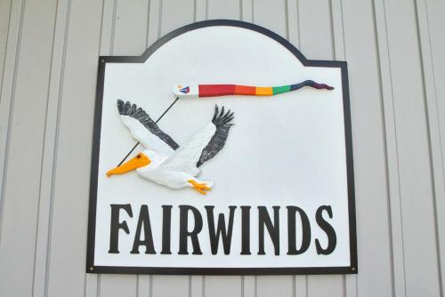 a sign on a wall with two birds flying at Fairwinds by Oak Island Accommodations in Caswell Beach
