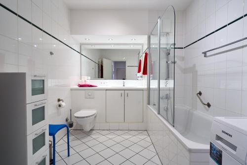 a white bathroom with a shower and a toilet at Apartment Sun Balcony Dresden Friedrichstadt in Dresden