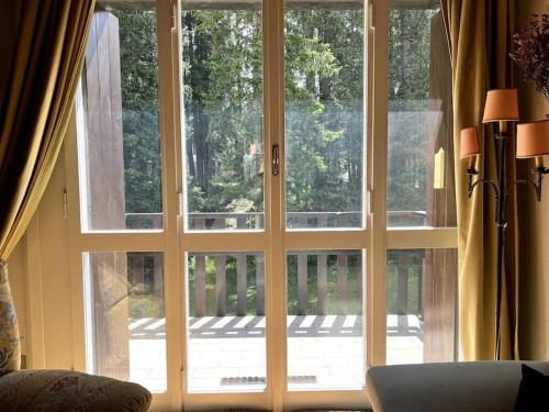 a large glass door with a view of a porch at Cosy Lodge in Madonna di Campiglio