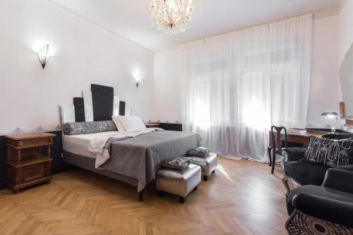 um quarto com uma cama, uma cadeira e um lustre em La casa di Gatsby lusso in pieno centro con parcheggio em Gorizia