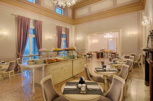 Un restaurante con mesas y sillas y un buffet. en GH Palazzo Suite & SPA, en Livorno