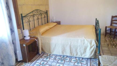 um quarto com uma cama, uma mesa e uma cadeira em Rustico Zagara em Buseto Palizzolo