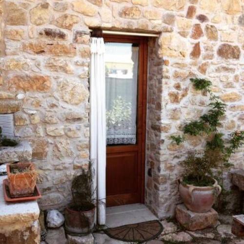 un edificio de piedra con una puerta de madera y una ventana en Rustico Zagara, en Buseto Palizzolo