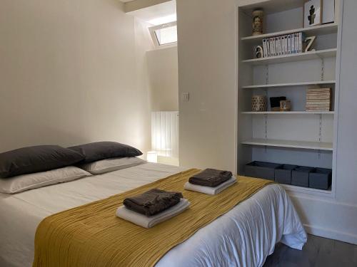 une chambre avec un lit avec deux serviettes dessus dans l'établissement Pied à terre en plein coeur de Montmorency, à Montmorency