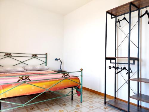 um quarto com uma cama com uma estrutura de metal em Eco House San Michele em San Michele