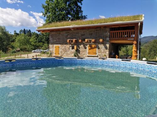 a large swimming pool in front of a building at Cabana Casa de Piatra, de la Mara in Deseşti