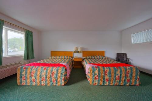 Habitación de hotel con 2 camas y ventana en Budget 8 Motel, en John Day