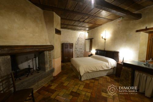 um quarto com uma cama e uma lareira em Dimore Santa Maria em Carbognano