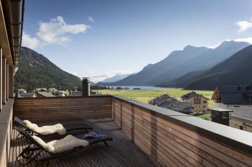 a balcony with a view of a lake and mountains at Hotel Cervo in Sils Maria
