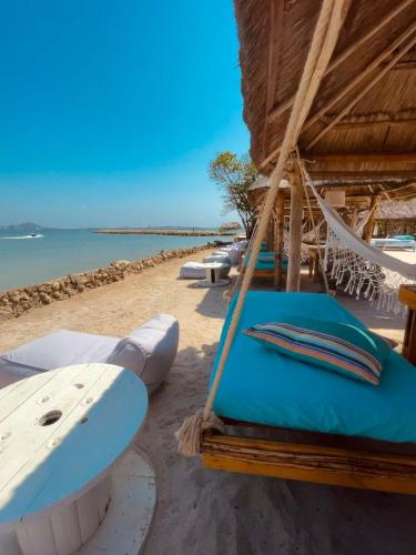 a bunch of surfboards and a hammock on a beach at Namaste Beach Club & Hotel in Tierra Bomba