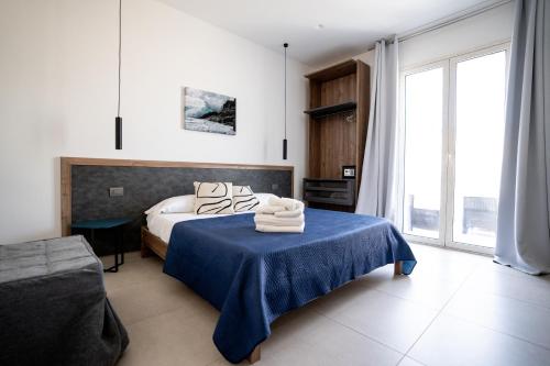 a bedroom with a bed and a table with towels on it at B&B il Colibrì in San Vito lo Capo