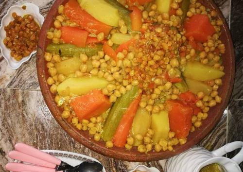 una ciotola di cibo con ceci e verdure su un tavolo di GITE TAGMA a Berkane