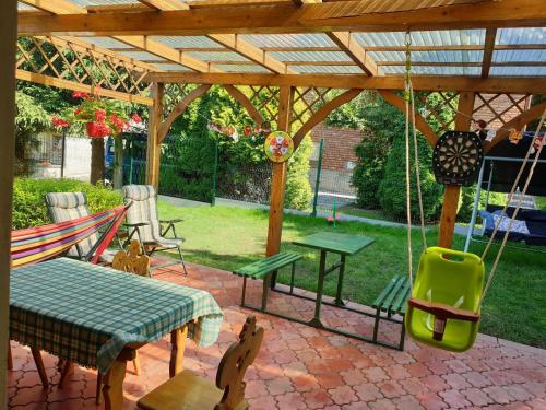 d'une terrasse avec une balançoire, une table et un hamac. dans l'établissement A summer house Zarabie Domek letniskowy Zarabie, à Myślenice